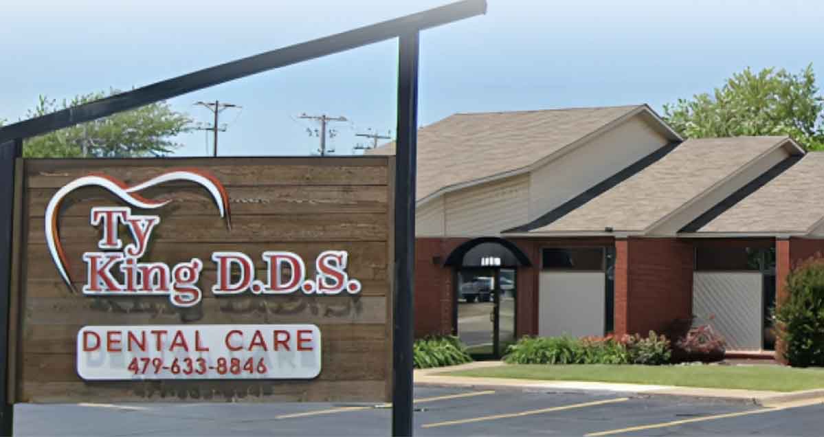 Ty King D.D.S. dental office exterior with brown brick building and wooden entrance sign.